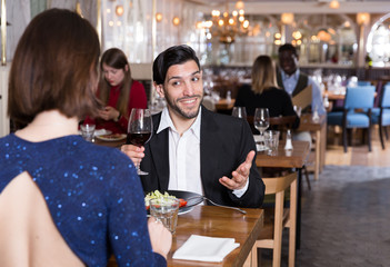 Cheerful man with female in restaurant