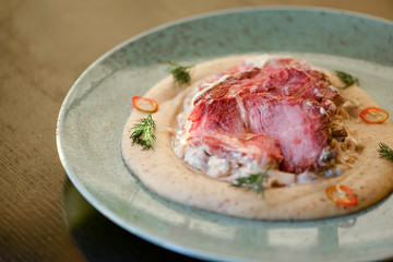 Fresh grilled beef steak on a blue plate over dark rustic wooden table. Traditional dish. Dinner in restaurant.