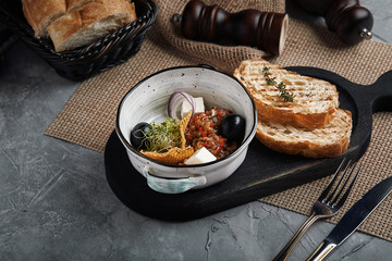 Vegetable stew with feta cheese and olives, beautifully laid out on a table. Traditional Greek cuisine.