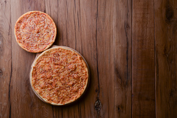 Two pizzas on the dark rustic wooden table. Flat lay, top view. Copy space web design banner.