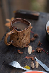 ceramic mug with hot drink from spices stand outdoors in autumn