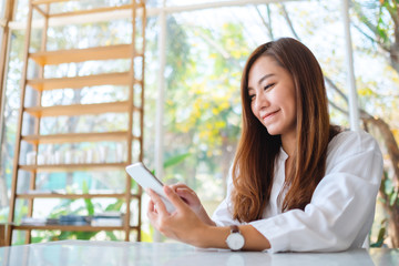 Closeup image of a beautiful asian woman holding and using mobile phone