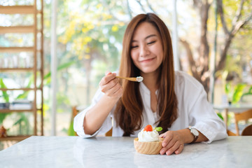 Closeup image of a beautiful asian woman enjoy eating an ice cream in restaurant