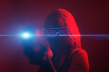 Girl with blaster in the futuristic battle. Concept virtual reality, cyber game.