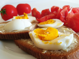 A light Breakfast of wholegrain bread, boiled eggs and tomatoes.