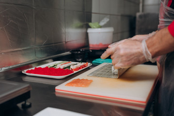 The chef prepares Japanese cuisine rolls