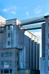 Old industrial buildings made of concrete against a blue sky. Concept of recession or economic growth. Vertical image. 