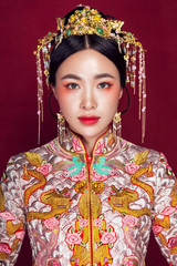 Asian brides in retro costumes on a crimson background