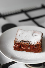 piece of chocolate sponge cake on a white plate
