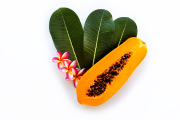 still life. Papaya on a white isolated background, decorated with tropical green leaf and plumeria flowers. melon tree, fruit