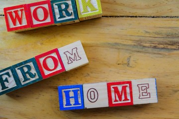 Wooden alphabet cubes on wooden table. Conceptual of work from home under normal occasions or lock...