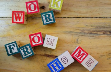 Wooden alphabet cubes on wooden table. Conceptual of work from home under normal occasions or lock...