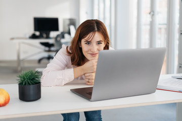 Fototapeta premium Businesswoman smiling as she reads her laptop