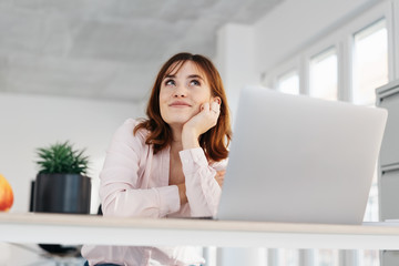Young businesswoman sitting daydreaming