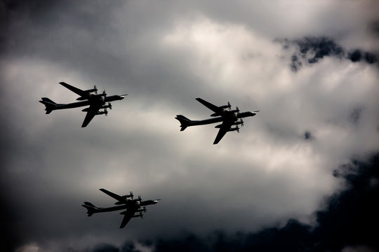 Three bombers fly against the sky in the shadow