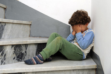 Little European Caucasian children crying sitting on the ground after being punished by parents - violence against minors