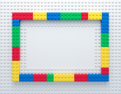 Frame Of Colorful Toy Bricks On White Construction Plate With Place For Your Content. 3d Rendering