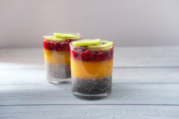 Detox and healthy superfoods breakfast concept. Vegan coconut milk chia seeds pudding with orange jelly and kiwi.