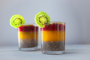 Detox and healthy superfoods breakfast concept. Vegan coconut milk chia seeds pudding with orange jelly and kiwi.