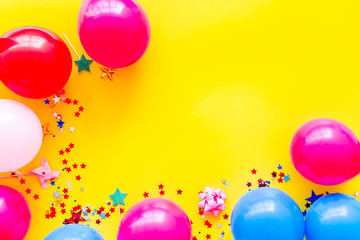Decorative frame with colorful balloons on yellow background top-down frame copy space