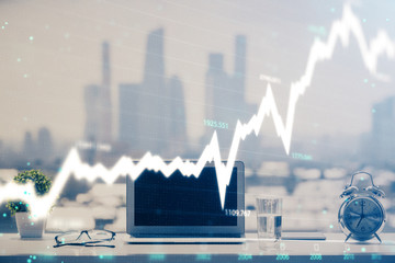 Forex graph hologram on table with computer background. Multi exposure. Concept of financial...