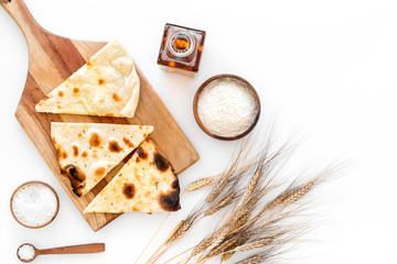 Focaccia ingredients. Wheat ears, flour, oil near bread on white background top-down