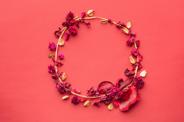 Round composition of dried flowers on a coral paper background. A wreath of grass and dried flowers. Flat lay, Copy space,