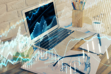 Fototapeta premium Financial graph colorful drawing and table with computer on background. Double exposure. Concept of international markets.