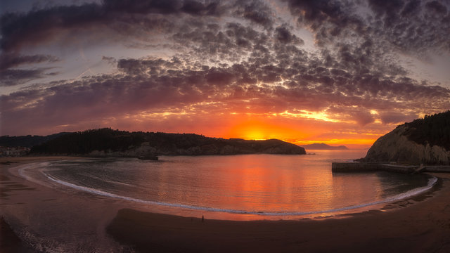 A colorful sunset with the hole view of the bay and beach of Gorliz (Euskadi). Big horizontal panorama.