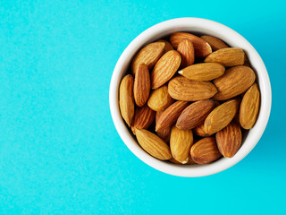 Almond nuts isolated on blue background.