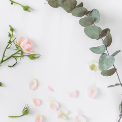 Bright romantic background with roses and eucalyptus. The place for an inscription. Flatlay, background.