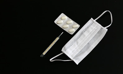 Pills, thermometer and medical mask close-up