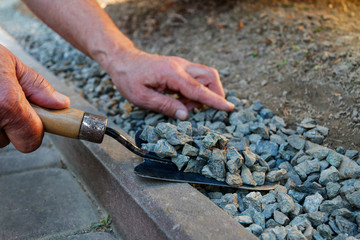 How to make a decoration from small pebbles next to a path in the garden.