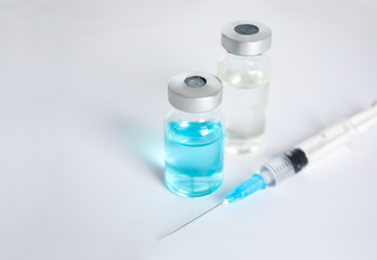 Vials and syringe on light background. Vaccination and immunization