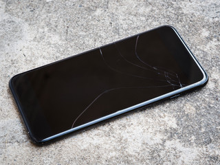 Broken smartphone display on the concrete floor.