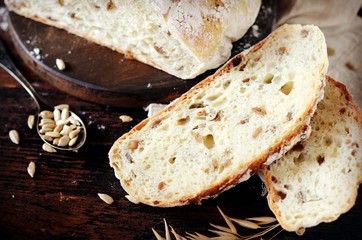 Homemade bread with sunflower seeds on a dark wooden background