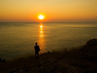 Silhouettle of man.He watching seaview and sunset on the hill.