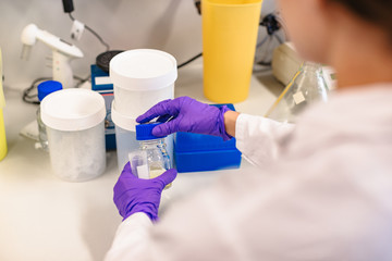 Obraz premium Scientist holding flask in front experiment boxes