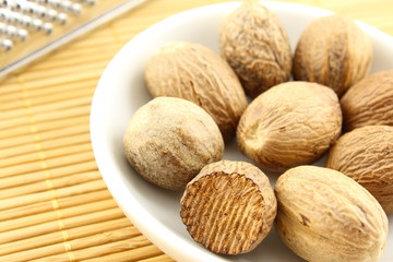 nutmeg seeds in a small white bowl