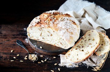 Homemade bread with sunflower seeds on a dark wooden background