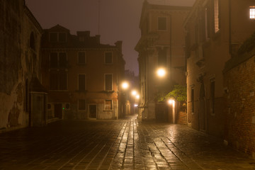 Venice street without people with night fog, Italy