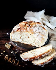 Homemade bread with sunflower seeds on a dark wooden background