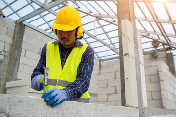 Obraz na płótnie Canvas Engineer worker,Construction build,Professional repairman in helmet.Man builder use hammer tool at construction site.