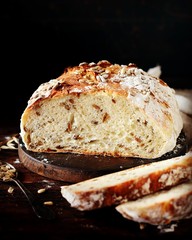 Homemade bread with sunflower seeds on a dark wooden background