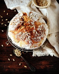 Homemade bread with sunflower seeds on a dark wooden background