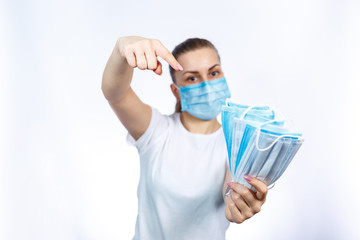 A girl in a protective medical mask holds in her hands means to protect the respiratory tract from the virus.