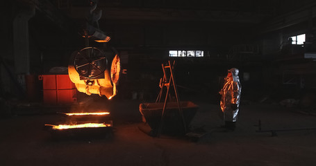 Smelting orange metal in a metallurgical plant. Liquid iron from the ladle