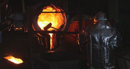 Smelting orange metal in a metallurgical plant. Liquid iron from the ladle