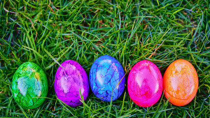 Ostereier aufgereiht auf grünem Rasen