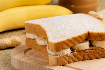 Peanut butter and banana sandwich on a wooden background